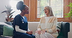 Senior woman, talking or caregiver in consultation for healthcare support or checkup at nursing home. Sofa, advice or African nurse speaking to mature female patient or person with cancer in clinic