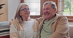 Senior couple, happiness and retired while laughing, talking and smile, couch and touch. Retirement, old age home and elderly in living room, couch and bonding together for quality time, hug or care