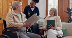 Elderly care, nurse and talking in home with people reading newspaper, book or tablet with discussion of support. Retirement, caregiver and relax in conversation house or living room with notebook