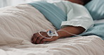 Healthcare, hand and iv with a patient in a hospital bed for recovery or rehabilitation closeup. Medical, wellness and treatment with a sick person lying in a clinic on a saline solution drip