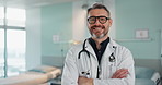 Healthcare, doctor and man with arms crossed at hospital with smile for support, service and wellness. Medicine, professional and expert with glasses and pride for career, surgery, insurance and care