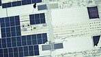 Overhead, solar power and a construction worker team on the roof of a building to install panel technology. Engineer, electricity and renewable energy with people working on a sustainability project