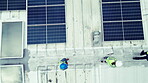 Overhead, solar energy and construction teamwork on the roof of a building to install panel technology. Engineering, electricity and renewable power with people working on a sustainability project