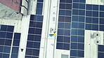 Overhead, solar energy and a construction team on the roof of a building to install panel technology. Engineer, planning and renewable electricity with people working on a sustainability project