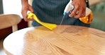 Hands, cafe and cleaning table with spray, cloth or chemical disinfection for hygiene in coffee shop. Closeup, restaurant worker or wipe wooden furniture surface for bacteria, dirt or safety in store