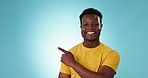 Man, face and pointing to advertising in studio for information, sales deal and choice on blue background. Happy portrait, african model and show mockup, promotion and announcement of news about us
