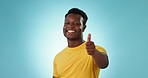 Thumbs up, man and face in studio for success, winning deal and bonus achievement on blue background. Portrait, happy african model and emoji of like sign for feedback, vote yes or support excellence