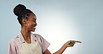 Steps, waitress or pointing in studio to mockup space in apron with menu, offer or cafe choice. Blue background, face or happy black woman advertising business, discount list or special deal promo 