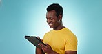 Typing, smile and black man with internet, tablet and connection on a blue studio background. African person, guy and model with tech, website information and social media with research and network