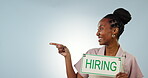 Pointing, happy or black woman with hiring sign, job advertising or business promo mockup space. Face, poster or waitress with board text, work opportunity or recruitment on blue background in studio
