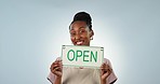 Smile, excited and open sign with a happy black woman in studio on a gray background for advertising. Portrait, cafe or coffee shop with a happy young employee marketing her small business startup