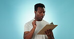 Thinking, planning and a black man with a solution, notes and writing ideas on a blue background. Creative, sstrategy and an African person or teacher with a clipboard for an agenda or schedule