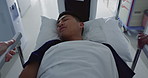 Asian man, patient and push bed in hospital for surgery, emergency or medical problem in corridor. Medicine, professional or person with stretcher for wellness, service and risk in clinic or job