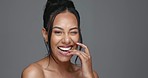 Face, skincare and happy woman wink in studio isolated on a gray background. Portrait, natural beauty and model flirting in spa facial treatment for aesthetic, glow and cosmetic wellness for health