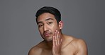 Asian man, face and skincare for grooming, hygiene or facial treatment against a grey studio background. Portrait of male person or model touching skin for self care, cosmetics or spa on mockup space