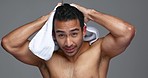 Man dry his hair, beauty and face with hygiene, treatment and shine with cosmetic care on grey background. Happy in portrait, towel and daily routine, shower and haircare with wellness in studio