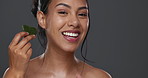 Woman, guasha and skincare for massage, facial and portrait or smile in studio by gray background. Happy model, cosmetics and dermatology in technique for beauty, self love and natural glow by tool