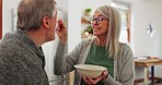 Eating, senior couple and feeding breakfast, taste test and care with help in marriage. Happy, talking and an elderly man  and woman with food, lunch and dinner for nutrition together in a house