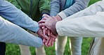 Elderly people, hands together and teamwork for community, trust or support together in nature. Mature or retired group piling in team building, collaboration or motivation for goals at outdoor park