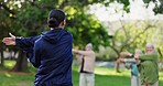 Woman, personal trainer and stretching in nature for elderly care, workout or outdoor exercise. Rear view of female person, coach or instructor training mature group of people at park for fitness