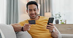 Man, credit card and phone for home online shopping, e commerce payment and subscription on sofa. Young, happy asian person relax on couch, mobile banking and loan application for streaming service