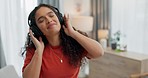 Happy woman, headphones and dancing to music in living room, relax or fun weekend at home. Female person smile and listening to sound track, songs or podcast in audio streaming in lounge at house