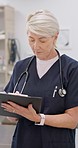 Clipboard, hospital and senior doctor writing notes for medical research, report and results. Healthcare, clinic and woman with checklist for patient documents, life insurance and wellness forms