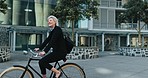 Businesswoman, happy and riding a bike to work, health and wellness. Mature person, smile and commute or transport to office, active and cardio in eco friendly, bicycle and carbon neutral footprint