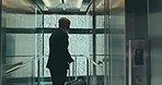 Elevator, travel and a mature black man at the office for business, corporate job or professional trip. Morning, arrival and an African manager with luggage or a suitcase for working at an airport