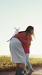 Child in field with toy, mom and hug while playing in freedom, nature and love with girl and woman. Happy, smile and running with airplane, playful mother and daughter bonding on countryside path.