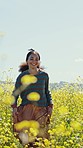 Happy woman, flower and field on adventure, travel and summer in countryside in grass. Vacation, walking and freedom on holiday with smile and nature with female person run and sunshine on trip