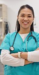 Smile, medical and an asian woman vet arms crossed in a clinic for health care or treatment. Portrait, vertical and a happy young doctor in a veterinary hospital for medicine or pet insurance