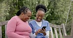 Nature, phone and nurse with senior woman on a bench in an outdoor garden networking on social media. Happy, laugh and African female caregiver scroll on cellphone with elderly patient in a field.