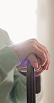 Closeup, hands and senior man with walking stick with disability in home for support, rehabilitation or sick in retirement. Healthcare, lonely senior and aid of wood cane for parkinson and arthritis