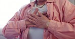 Hands on chest, closeup and senior woman in a living room with heart attack, pain or breathing problem at home. Zoom, anxiety and elderly female person with lungs massage for asthma emergency crisis