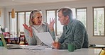 Senior couple, angry for bills and home debt, financial stress or budget risk with fight, argue and frustrated on laptop. Mature woman question man of documents, loan and bankruptcy paper on computer