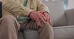 Knee pain, anxiety and hands of senior man on sofa with arthritis, problem or osteoporosis at home closeup. Zoom, injury and elderly male with leg massage in a living room with osteoarthritis issue