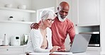 Senior couple, computer and planning for home, investment or budget, retirement and pension funding in kitchen. Interracial mature woman and man on laptop for asset management, loan or life insurance