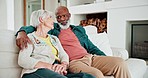 Hugging, discussion and senior couple in living room talking, bonding and relaxing on a sofa together. Conversation, love and elderly interracial man and woman in retirement speak in lounge at home.