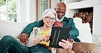 Old couple on sofa with tablet, laughing and relax with love, interracial marriage and bonding in home. Social media meme, digital app and happy people, senior man and woman on couch in living room.