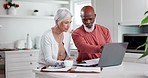 Senior couple, bills and documents on computer for home mortgage, budget planning and pension funding in kitchen. Interracial woman and man on laptop reading paperwork, retirement research or assets