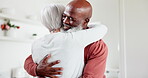 Interracial, couple and hug with love and happy at home, comfort with empathy or hello, peace and old people. Retirement, life partner with black man and woman in marriage with embrace in kitchen