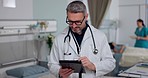 Man, doctor and tablet in research for healthcare, medical or Telehealth in communication at hospital. Male person, nurse or surgeon with technology for networking, study or online search at clinic