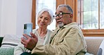 Senior couple, video call and talking with phone in home, living room and online communication with grandparents on sofa. Social media, chat and old people together in discussion, wave and smartphone