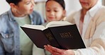 Religion, bible and family reading at their home for knowledge, faith and holy education. Spiritual, humble and people studying the book together for worship, trust and forgiveness at modern house.