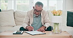 Budget, documents for insurance and a senior man planning on a sofa in the living room of his apartment. Paper, writing and home finance with an elderly person accounting for investment payment