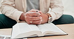 Hands, praying and Bible, cross for religion and God, Christian at home with closeup of prayer and study scripture. Worship, wellness and person has crucifix, faith and search for guidance with trust