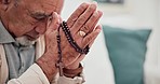 Old man, praying and hands, cross for worship and God, Christian at home with prayer and Jesus Christ. Religion, wellness and crucifix for faith and search for guidance with trust and gratitude 