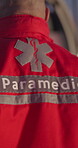 Back, man and paramedic walking for emergency, ems service and healthcare in city. Rear view, medical professional and doctor outdoor at night for first aid, rescue operation and working by ambulance