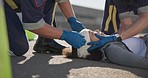 Paramedic team, woman and accident on street for brain injury, concussion and medical attention. First responder, healthcare expert and emergency on road for head bandage, support or safety on ground